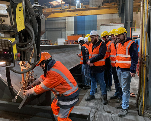 Groupe d'étudiants en observation devant l'accomplissement d'une soudure.
